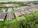 Aerial view of a neighborhood with well-maintained lawns and landscaping near a pond at 412 Daylily Blvd, Nokomis, FL 34275