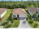 Aerial view of a single-story home with brick paved driveway, well-maintained lawn, and tropical palm trees at 412 Daylily Blvd, Nokomis, FL 34275