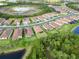 Aerial view of a neighborhood with well-maintained lawns and landscaping near a pond at 412 Daylily Blvd, Nokomis, FL 34275