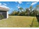 Spacious backyard featuring a well-kept lawn, mature trees, and a modern black fence, offering both beauty and privacy at 412 Daylily Blvd, Nokomis, FL 34275