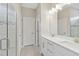 Well-lit bathroom featuring double vanity, quartz countertops, and a tiled glass-door shower at 412 Daylily Blvd, Nokomis, FL 34275