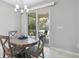 Cozy dining area with a round table and chairs, featuring access to the outdoor patio at 412 Daylily Blvd, Nokomis, FL 34275