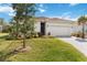 Charming home featuring a tile roof, well-kept lawn, and a paved driveway leading to the garage at 412 Daylily Blvd, Nokomis, FL 34275
