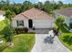 Beautiful single-story home with a red tile roof, manicured landscaping, and a paver driveway at 412 Daylily Blvd, Nokomis, FL 34275