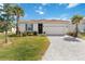 Charming single-story home featuring a paved driveway and a well-manicured lawn at 412 Daylily Blvd, Nokomis, FL 34275