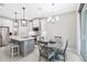 Modern kitchen with white cabinetry, stainless steel appliances, and a dining area, ideal for Gathering meals at 412 Daylily Blvd, Nokomis, FL 34275
