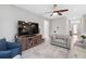 Comfortable living room with a large television, ceiling fan, and neutral decor, perfect for relaxing at 412 Daylily Blvd, Nokomis, FL 34275
