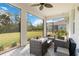Screened-in patio features stylish outdoor furniture, a ceiling fan, and serene backyard views, ideal for relaxing and entertaining at 412 Daylily Blvd, Nokomis, FL 34275