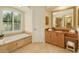 Bright bathroom featuring a soaking tub with natural light from the large window at 4668 Tuscana Dr, Sarasota, FL 34241