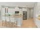 Spacious kitchen with white cabinetry, stainless steel appliances, and eat-in island with barstool seating at 4668 Tuscana Dr, Sarasota, FL 34241