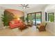 Comfortable living room with mural, cozy furnishings, and view of the pool through sliding glass doors at 4668 Tuscana Dr, Sarasota, FL 34241