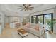 Open-concept living room with tile flooring, neutral decor, modern ceiling fan, and sliding glass doors to outdoor space at 4668 Tuscana Dr, Sarasota, FL 34241
