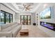 Cozy living room with a modern fireplace, tiled floors, and sliding glass doors overlooking the outdoor pool at 4668 Tuscana Dr, Sarasota, FL 34241