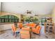 Spacious outdoor living area with a full kitchen, comfortable seating, and large arched windows overlooking lush greenery at 4668 Tuscana Dr, Sarasota, FL 34241