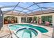 Inviting backyard pool and spa surrounded by tiled deck with seating areas under a modern screened enclosure at 4668 Tuscana Dr, Sarasota, FL 34241