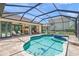 Sparkling pool with jacuzzi, travertine tile decking and covered patio in a private backyard at 4668 Tuscana Dr, Sarasota, FL 34241