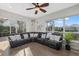 Bright living room features a comfortable leather sectional, ceiling fan, and large windows at 4715 Spinnaker Dr, Bradenton, FL 34208