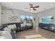 Bright living room features a comfortable leather sectional, ceiling fan, and large windows at 4715 Spinnaker Dr, Bradenton, FL 34208