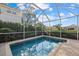 Inviting screened-in pool surrounded by lush landscaping and brick patio at 4715 Spinnaker Dr, Bradenton, FL 34208