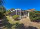 Backyard featuring manicured lawn, lush landscaping, screened-in patio and sparkling pool at 4729 Peridia E Blvd, Bradenton, FL 34203