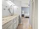 Bathroom with double sinks, framed mirror and a view into the bedroom at 4729 Peridia E Blvd, Bradenton, FL 34203