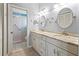 Well-lit bathroom featuring a double vanity, round mirrors and updated shower at 4729 Peridia E Blvd, Bradenton, FL 34203