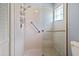 Shower with white tiling, glass door, and handrails installed at 4729 Peridia E Blvd, Bradenton, FL 34203