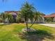 Inviting front yard with lush green lawn and mature palm trees at 4729 Peridia E Blvd, Bradenton, FL 34203