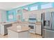 Bright eat-in kitchen with stainless steel appliances, island, and blue walls filled with natural light at 4729 Peridia E Blvd, Bradenton, FL 34203