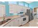 Bright kitchen with stainless steel appliances, white cabinets and blue walls filled with natural light at 4729 Peridia E Blvd, Bradenton, FL 34203