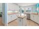 Kitchen with granite counters, white cabinets, dishwasher and island adjacent to sun-lit dining area at 4729 Peridia E Blvd, Bradenton, FL 34203