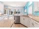 Kitchen with granite counters, white cabinets, dishwasher and sink with natural light from adjacent dining area at 4729 Peridia E Blvd, Bradenton, FL 34203