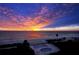 Breathtaking beachfront view with a pool under a vibrant sunset sky at 4835 Gulf Of Mexico Dr # 106, Longboat Key, FL 34228