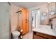 Bathroom with tiled floor and walls, walk-in shower, toilet, and wooden cabinet at 517 Tampico Dr, North Port, FL 34287
