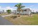 Manufactured home boasts a well-maintained lawn, mature landscaping, and an expansive view at 517 Tampico Dr, North Port, FL 34287