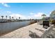 Waterfront patio with chairs, a grill, and views of the canal at 517 Tampico Dr, North Port, FL 34287