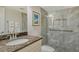 Bathroom with a glass shower, granite countertop, and tiled walls at 5230 Landings Blvd # 101, Sarasota, FL 34231