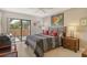 Bedroom featuring a bed with a gray plaid blanket, lamps on nightstands, and an outdoor terrace at 5230 Landings Blvd # 101, Sarasota, FL 34231