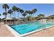 Sparkling community pool with palm trees, lounge chairs, and shaded cabanas, ideal for relaxation at 5230 Landings Blvd # 101, Sarasota, FL 34231