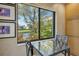 Bright breakfast nook features a glass-top table and scenic views of the water and lush tropical foliage at 5230 Landings Blvd # 101, Sarasota, FL 34231