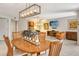 Open-concept dining area with modern lighting and comfortable seating flows into the living room at 5230 Landings Blvd # 101, Sarasota, FL 34231