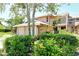 Charming townhome exterior featuring lush landscaping and a private two-car garage at 5230 Landings Blvd # 101, Sarasota, FL 34231