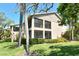 Exterior view of the building with mature trees, lush landscaping and sunlit lawn at desirable community at 5230 Landings Blvd # 101, Sarasota, FL 34231