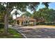 Picturesque guard house at The Landings with a tiled roof surrounded by lush greenery and mature trees at 5230 Landings Blvd # 101, Sarasota, FL 34231