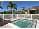 Relaxing community hot tub area surrounded by a white fence, set against a backdrop of lush landscaping at 5230 Landings Blvd # 101, Sarasota, FL 34231