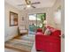 Cozy sitting room with a plush red sofa, and sliding glass doors leading to the outdoor patio at 5230 Landings Blvd # 101, Sarasota, FL 34231