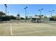 Community tennis courts featuring lighting, benches, and a well-kept playing surface at 5230 Landings Blvd # 101, Sarasota, FL 34231