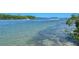 Picturesque water view with a boat passing by, surrounded by natural vegetation, offering a serene coastal atmosphere at 5230 Landings Blvd # 101, Sarasota, FL 34231