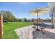 Backyard featuring a patio set, an umbrella, and a lush green lawn at 5231 32Nd E St, Bradenton, FL 34203