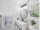 Bathroom vanity with modern light fixtures, round mirror, and decorative towels at 5231 32Nd E St, Bradenton, FL 34203